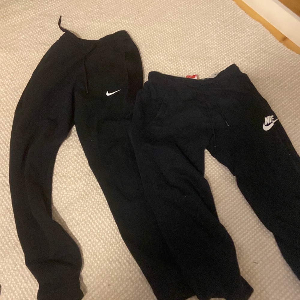 two pairs of black Nike sweats
